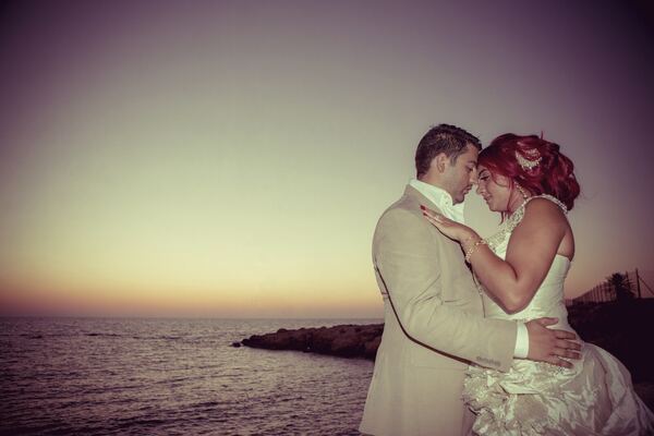 Bride and groom by the sea at sunset in Paphos, photographed by Evagoras Mandrides