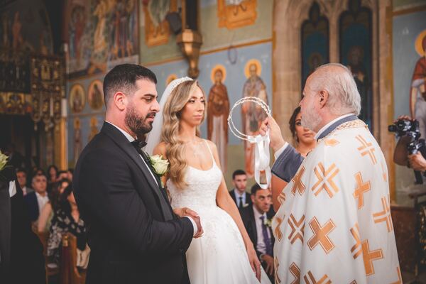The priest blessing the couple at a Greek Orthodox wedding in Hertfordshire, photographed by Evagoras Mandrides