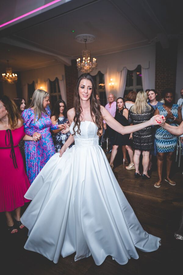 The bride dancing at a wedding reception at Offley Place, Hertfordshire, photographed by Evagoras Mandrides